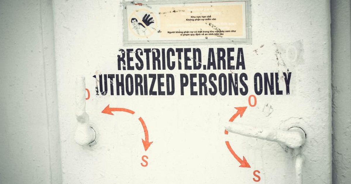 Cartel de zona restringida, solo personal autorizado, en una puerta metálica