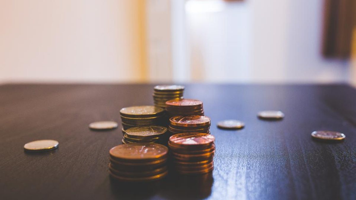 Monedas apiladas sobre una mesa oscura