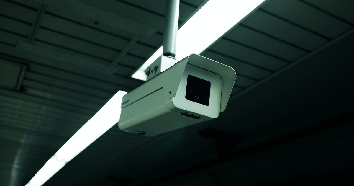 Cámara de videovigilancia fija en el techo de una sala de oficinas
