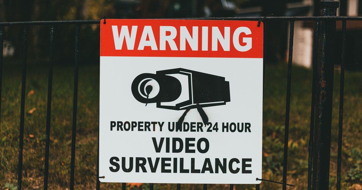 Cartel de aviso de videovigilancia 24 horas colocado en una valla