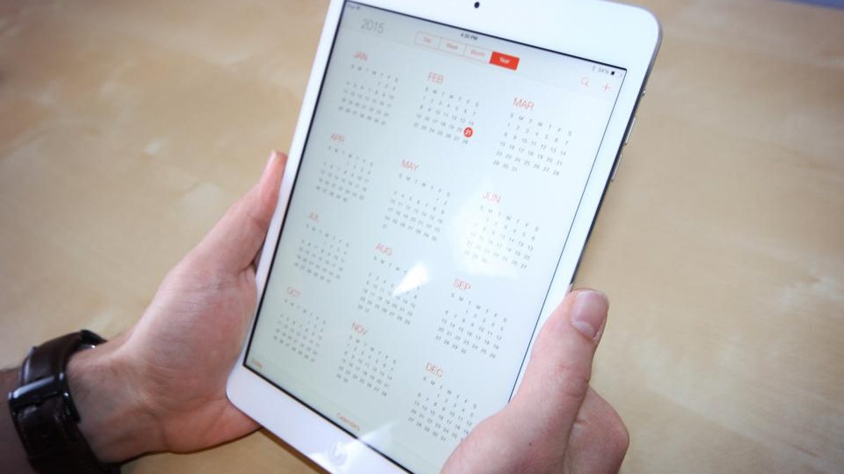 Manos sosteniendo una tableta con un calendario en pantalla