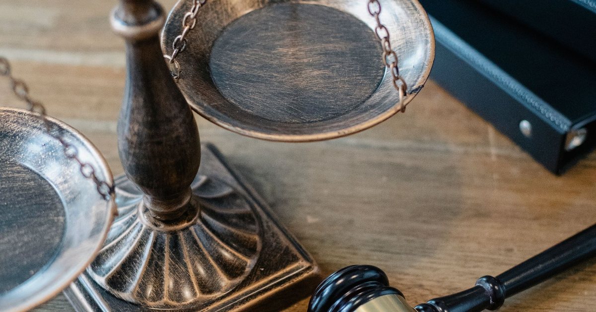 Balanza de la justicia y mazo de juez sobre una mesa de madera