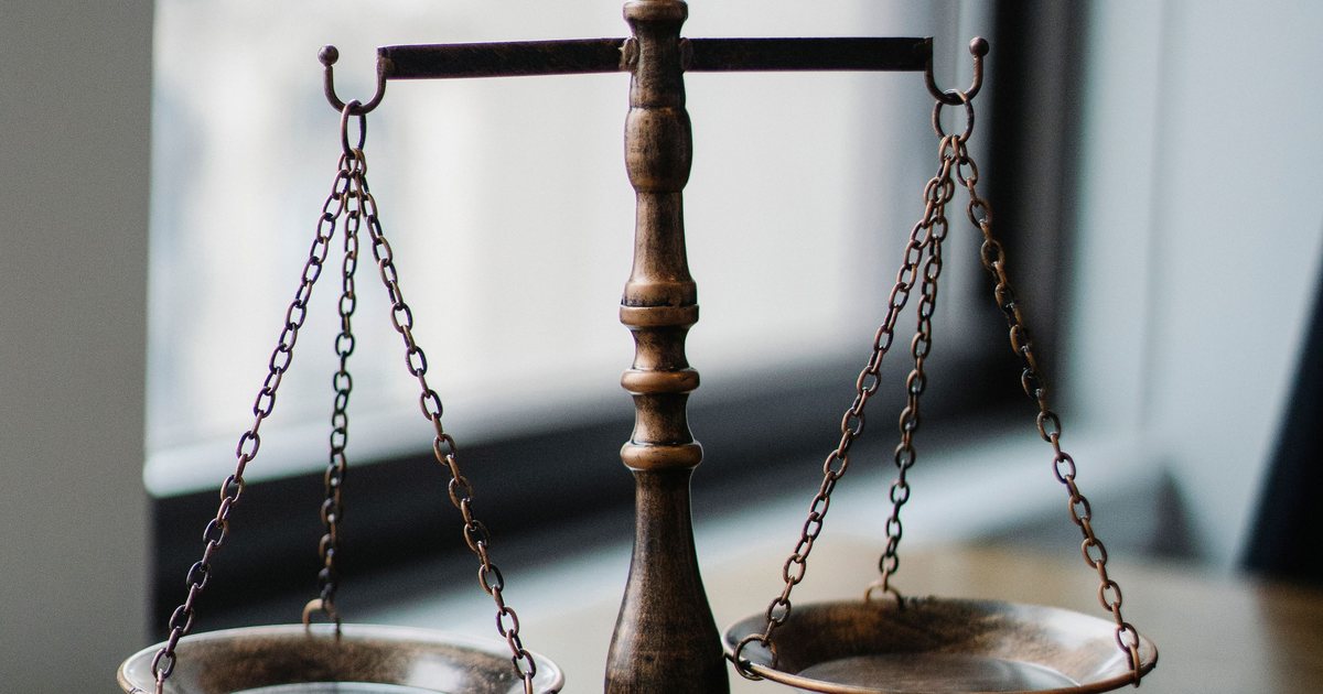 Balanza de la justicia junto a un mazo sobre una mesa