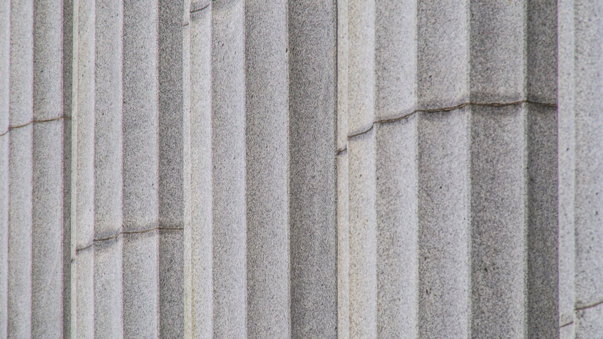 Primer plano de las columnas de piedra de un edificio institucional