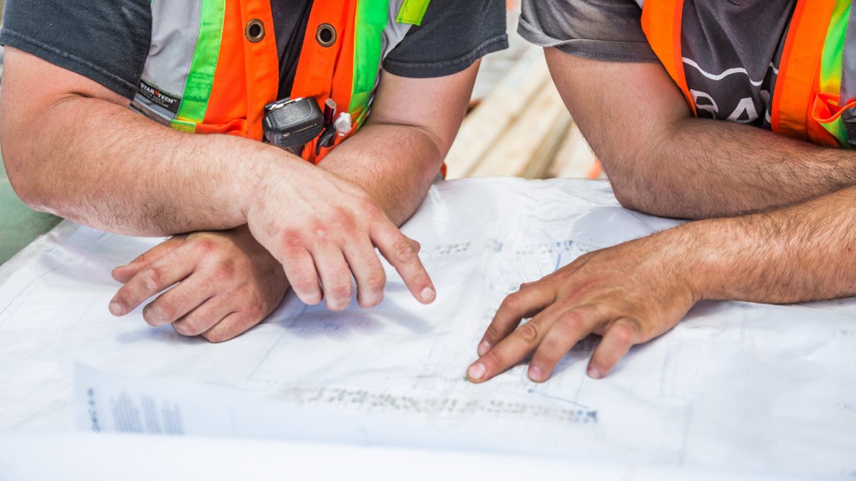 Dos personas revisando unos planos técnicos sobre una mesa