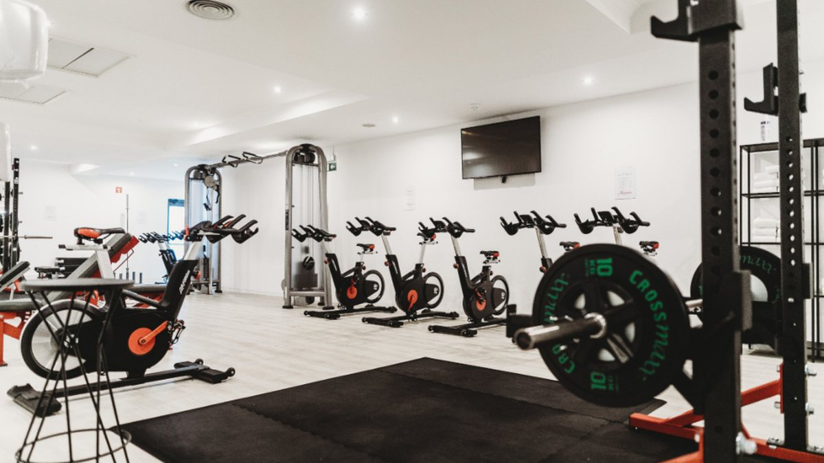 Interior de un gimnasio con bicicletas estáticas y pesas