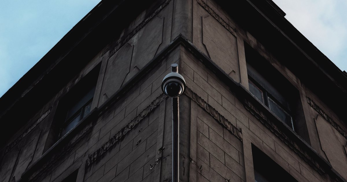 Cámara de videovigilancia en la esquina de un edificio contra el cielo