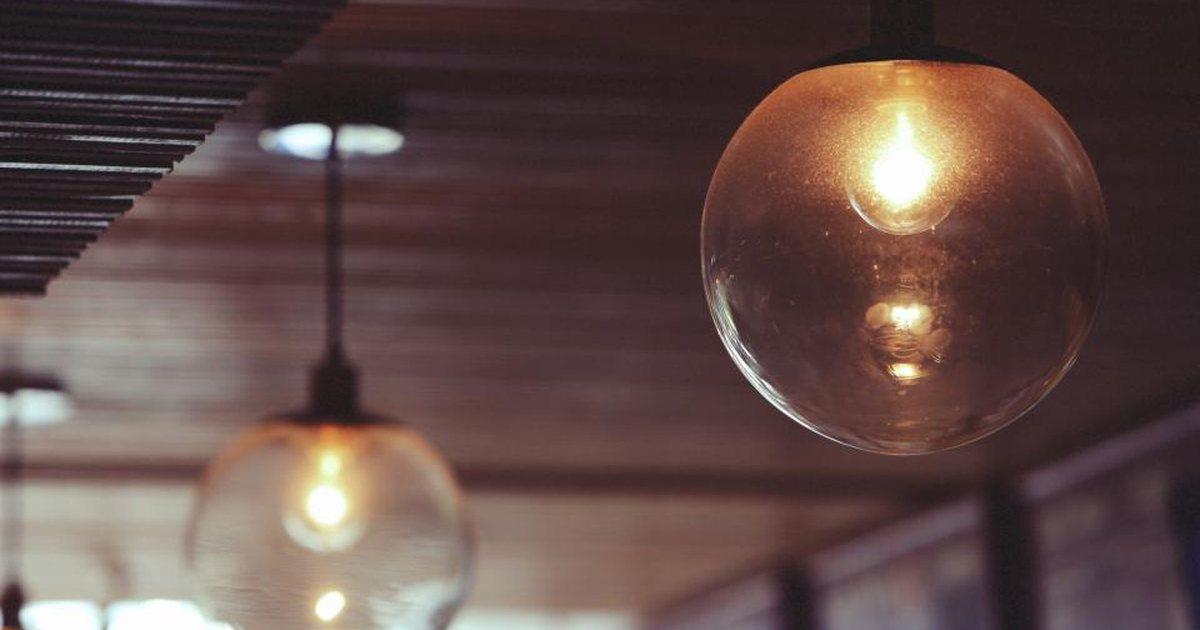 Dos bombillas colgantes encendidas bajo un techo de madera
