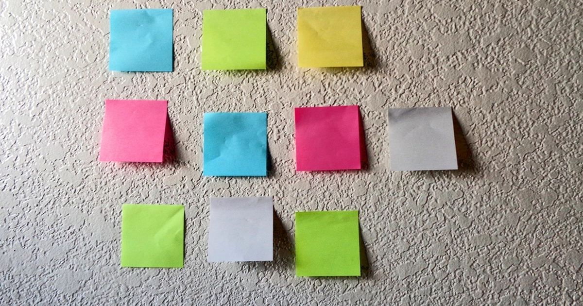 Notas adhesivas de colores organizadas en una cuadrícula sobre una superficie