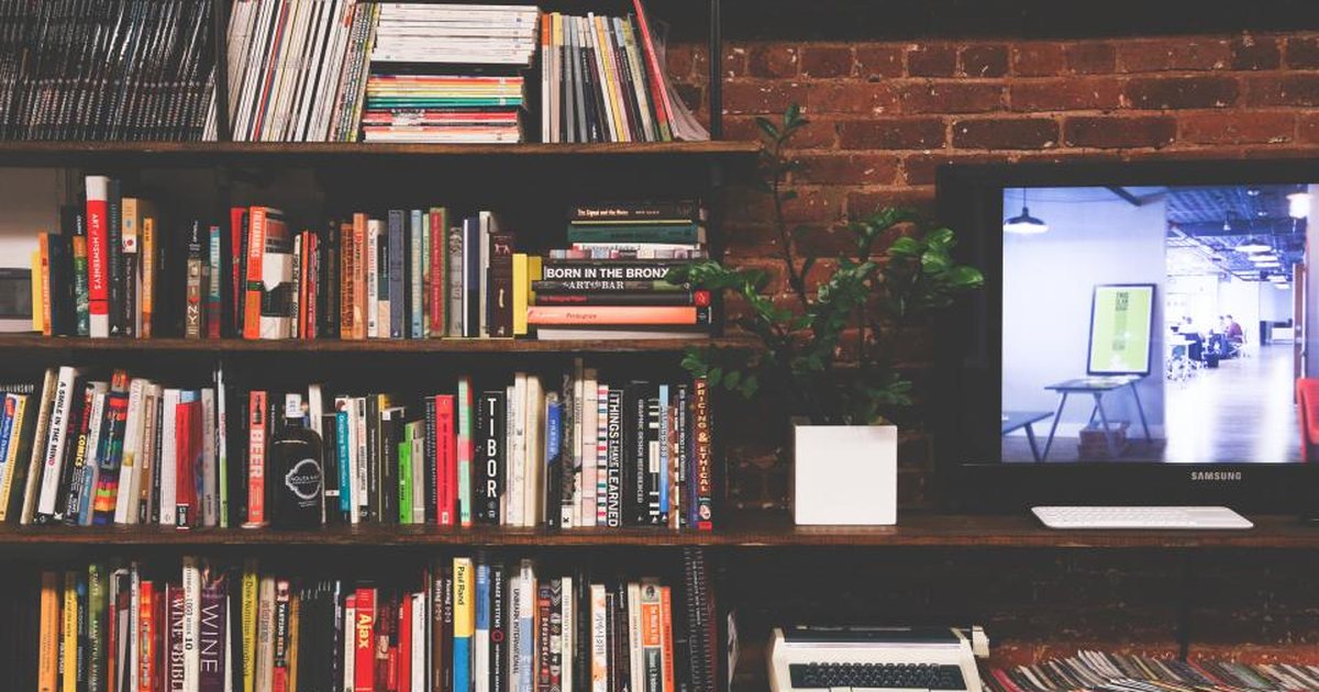 Estantería con libros junto a una pared de ladrillo visto, en un ambiente acogedor