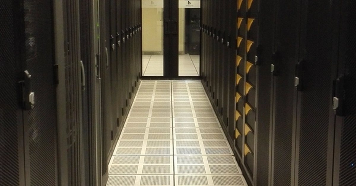 Pasillo de un centro de datos con estanterías de servidores a ambos lados, iluminación cenital